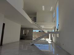 Sala ampla com escada de degraus abertos e janelas altas.